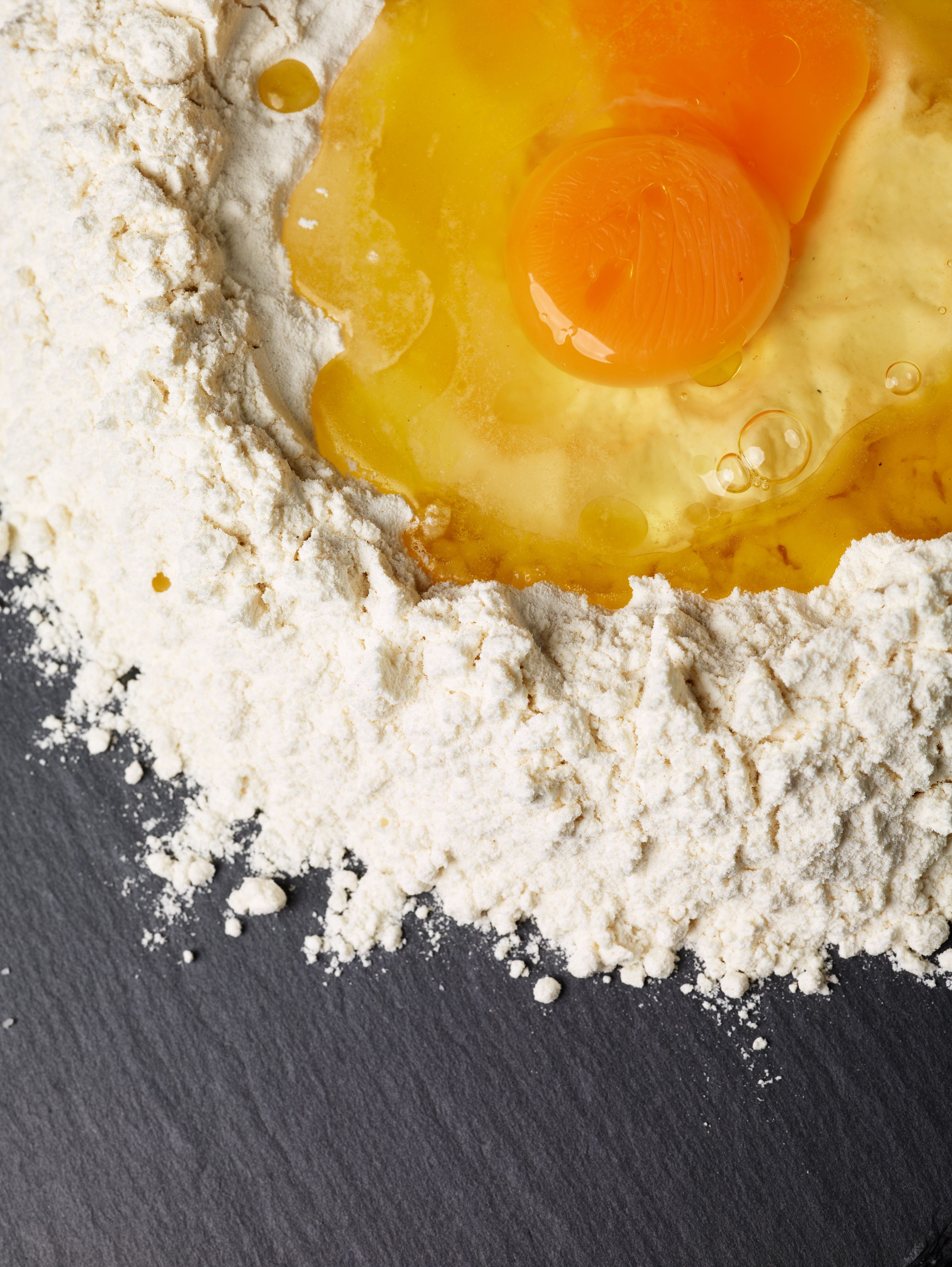 An egg in a heap of flour before mixing